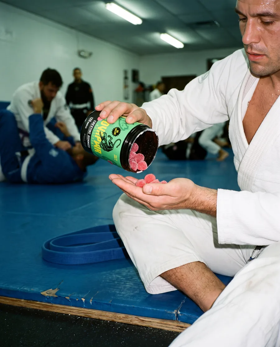 En gi, sirviéndose gomitas del tarro al borde del tatami